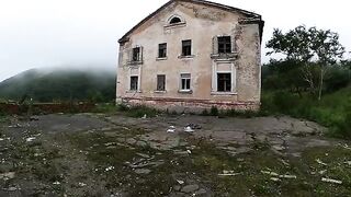 A chick is walking around horrible buildings, and suddenly she kneels down