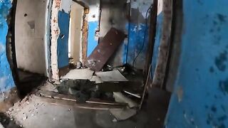 A chick is walking around horrible buildings, and suddenly she kneels down