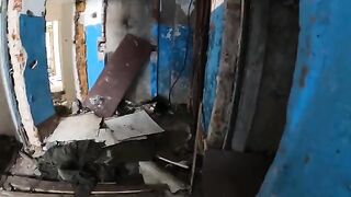 A chick is walking around horrible buildings, and suddenly she kneels down
