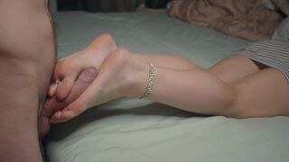 A petite girl is showing her feet and performing a foot job