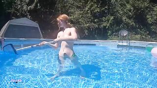 Redhead in red bikini underwater in the swimming pool