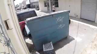 The couple got close while the camera captured behind the garbage tank