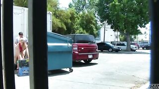 The couple got close while the camera captured behind the garbage tank