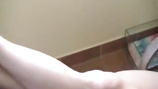 A naked girl with big natural tits is smoking on the sofa