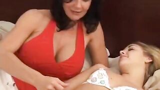 Lesbian beauties fuck each other with a strapon in the bedroom