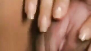 A woman with a large clitoris plays with her hairy pussy