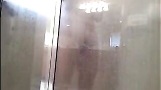 A man washes his body in the shower, but he does not know that he is being filmed