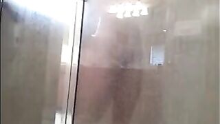 A man washes his body in the shower, but he does not know that he is being filmed
