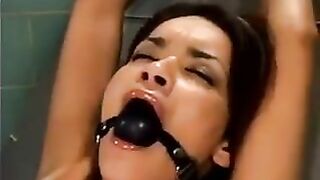 A bald guy is raping a girl with the help of a sex machine