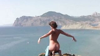 A cute girl poses naked on the beautiful beach and enjoys herself