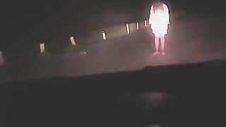 A sexy lady in white was filmed at a crossroads, showcasing her curves