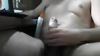 A man sits in front of the computer and masturbates his cock