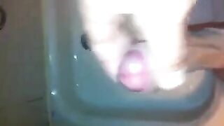 The kid caresses his dick under the shower jet stream