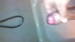 The kid caresses his dick under the shower jet stream