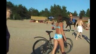 A topless beauty is having fun on the beach, showing her body