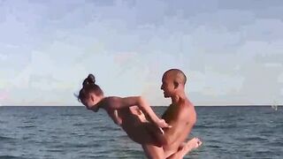A group of acrobats have fun on the naked beach