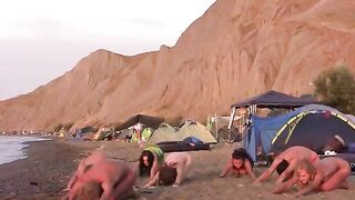 A group of young people are playing volleyball naked on the beach